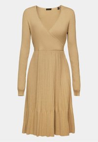 Beige ribbat stickad klänning med V-ringning, långa ärmar och utsvängd nederkant. Har en omslagsdesign och strukturerad tyg.