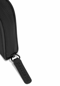 Bolsa con cremallera negra hecha de tela texturizada, que presenta un tirador de cremallera negra suave con una etiqueta del logo "pactastic" en relieve. Diseño compacto.