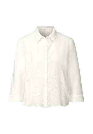 Camicia bianca con maniche a tre quarti, dotata di orlo scallop e dettagli ricamati a intaglio nella parte inferiore. Realizzata in tessuto leggero.