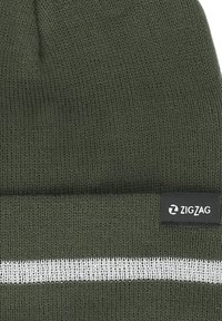 Vihreä neulepipo, jossa on valkoinen vaakasuora raita ja pieni musta etiketti, jossa on "ZIGZAG" -logo sivussa. Pehmeä rakenne.