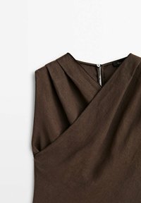 Robe en lin marron avec un design croisé, des plis aux épaules et une fermeture à bouton à l'arrière. Tissu lisse et texturé.