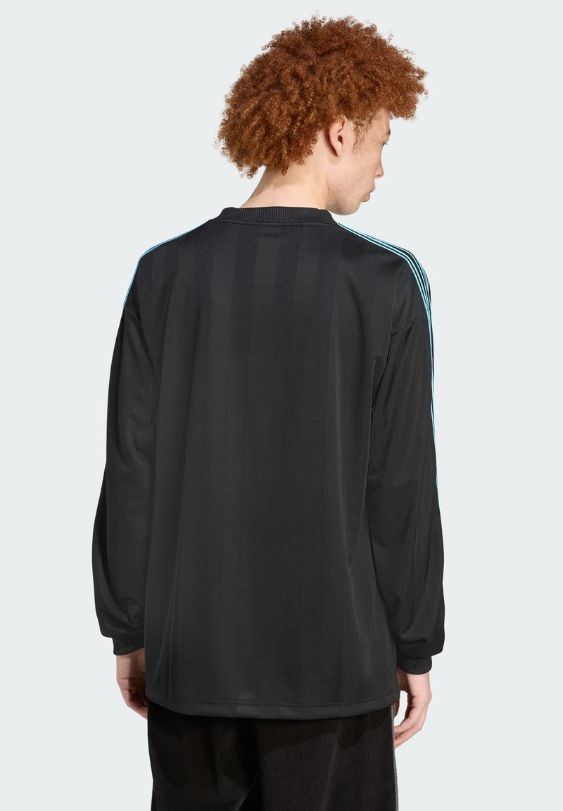 Langsleeve zwart jersey met horizontale strepen, lichtblauwe schouderaccenten en een geribbelde ronde hals. Zacht, gemerceriseerd materiaal.