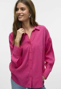Fuchsia knap-ned skjorte med krave, lange ærmer og afslappet pasform. Glat tekstur; har en enkelt lomme og en diskret glans.