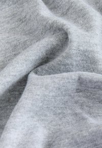 Tejido de punto gris con una textura suave, que presenta un sutil patrón jaspeado y una superficie lisa, tejido de cerca para mayor durabilidad.