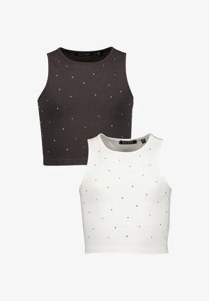 Deux tops courts sans manches, un noir et un blanc, chacun décoré de petites chevilles en argent dispersées.