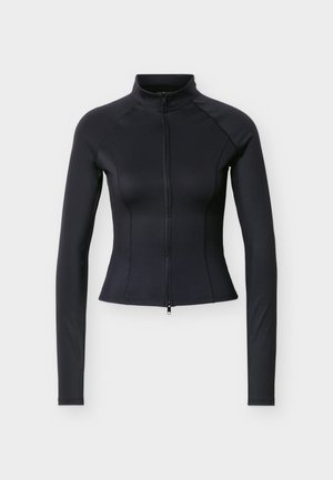 Sort tettsittende jakke med lang erm, høy krage og glidelåslukking foran, fotografert mot en ensfarget lys grå bakgrunn.