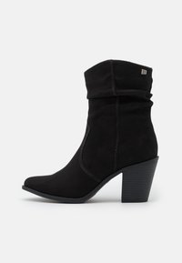 Czarne botki za kostkę z sztucznego zamszu o luźnym fasonie, z wąskim noskiem i fakturowanym obcasem w kształcie bloku. Posiadają subtelne szwy i akcent z logo.