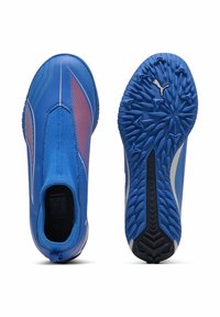 Scarpe sportive blu con una tomaia sintetica liscia, dettagli testurizzati e una suola con motivo. Presentano un design slip-on e il logo PUMA.