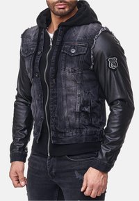 denim en leren jack met een verweerd uiterlijk, twee borstzakken, zwarte mouwen en een capuchon. Inclusief badge-detail op de mouw.