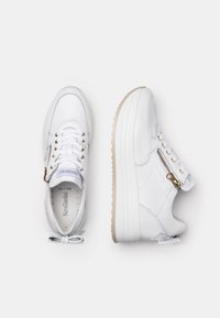Hvide lædersneakers med en hævet sål, prydet med guldfarvede detaljer, snørebåndsdesign og en lynlås på siden for nem adgang.