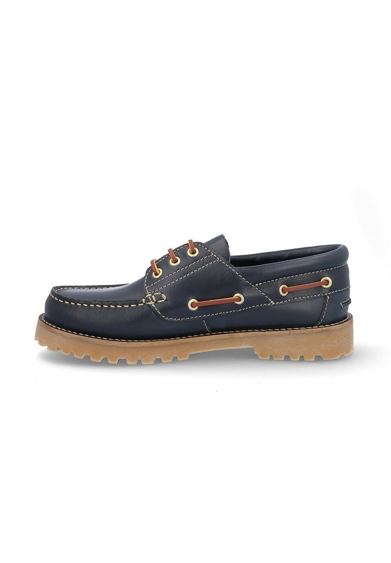 Zapato de barco de cuero azul marino con puntera redonda, suela de goma marrón, costuras en contraste y ojales marrones para los cordones. Diseño clásico de calzado sin cordones.