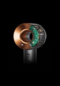 Föhn met een metalen koperen mondstuk, transparante behuizing die de interne bedrading onthult, zwarte handgreep met ronde bedieningselementen.