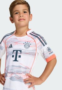 Detský dres FC Bayern Mníchov, biely s ružovými a sivými abstraktnými vzormi, krátke rukávy, oranžové akcenty a logá sponzorov na rukávoch.