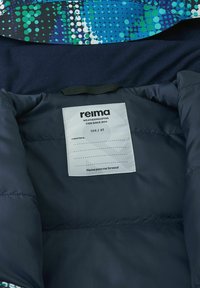 Navy blue puffer jacket interior with a colorful, patterned fabric trim. Includes a care label with brand and size details on a white background.