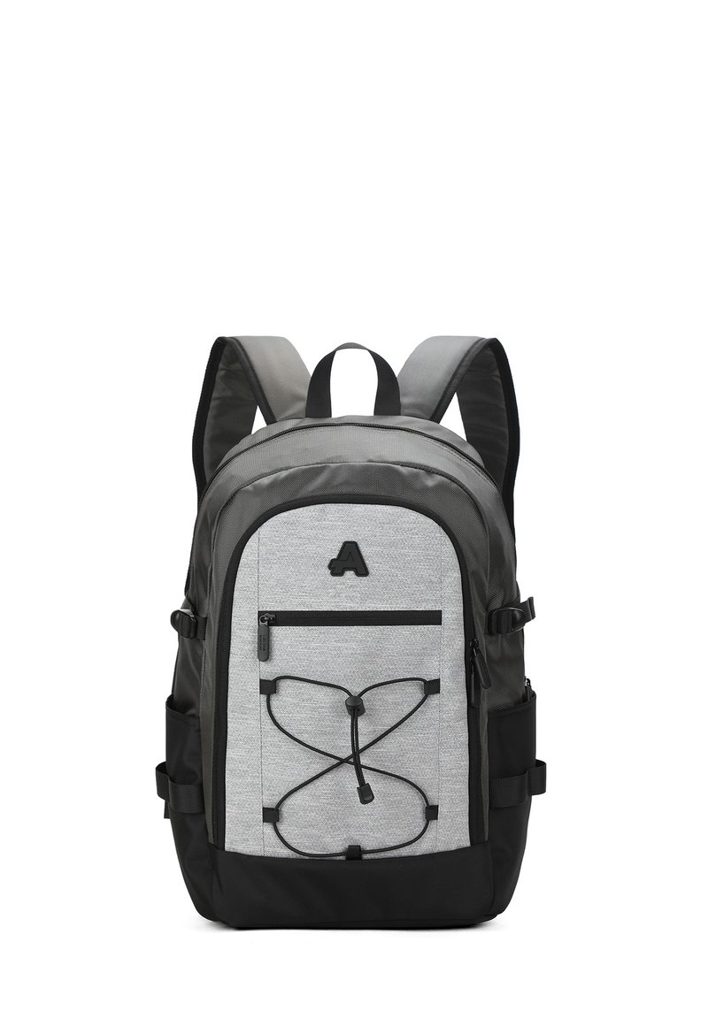 Sac à dos gris et noir, au design rectangulaire, fabriqué en tissu, comprenant une poche zippée à l'avant et un cordon élastique pour un rangement supplémentaire.