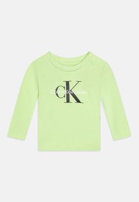 Jasnozielona, bawełniana koszula z długim rękawem, z okrągłym dekoltem, zapięciem na zatrzask na ramieniu oraz czarnym logo "Calvin Klein Jeans".