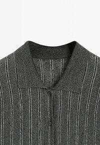 Dark gray knitted polo shirt with vertical white and black stripes and two black buttons on the front placket.