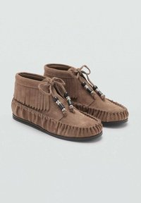 Botas de ante marrón hasta el tobillo con detalles de flecos, cierre con cordones, acentos de cuentas, bordes cosidos y suela de goma plana.