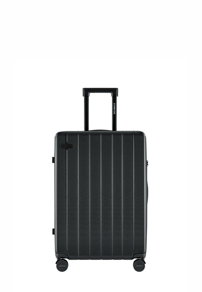 Schwarzer Hartschalenkoffer mit vertikalen Rippen, ausziehbarem Griff und vier glatten Rollen für einfache Manövrierbarkeit. Verschluss oben.