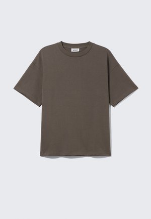 Donkergroene katoenen T-shirt met ronde hals, korte mouwen en een relaxte pasvorm, met een label dat "WEEKDAY" zegt.