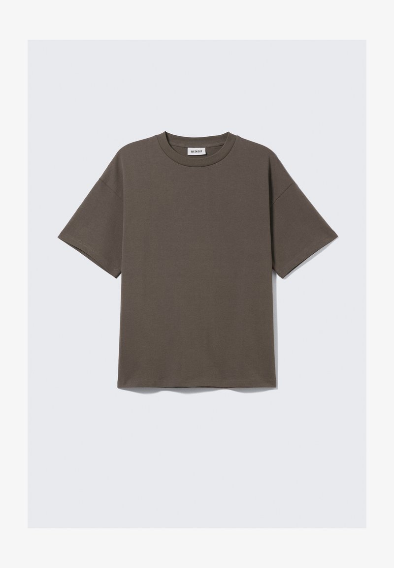 T-shirt en coton vert foncé avec un col rond, des manches courtes et une coupe ample, portant une étiquette avec le mot "WEEKDAY".