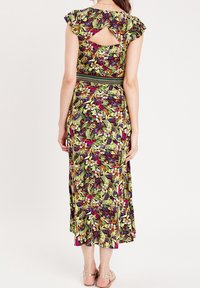 Blumiges Maxikleid mit Rüschensäumen, lebhaftem Grün, lila und gelbem Muster, mit einem Rückenschlitz und strukturierter Taille.