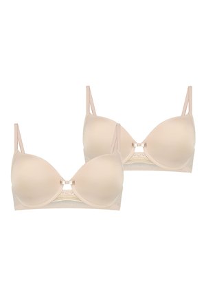 Due reggiseni color carne con coppe modellate e lisce, spalline regolabili e dettagli in pizzo sulla fascia con un fiocco decorativo centrale.