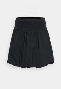 Svart skjørt har et bredt elastisk liv og en sammensatt, lett stoffdesign som gir en flytende form med en subtil tekstur.