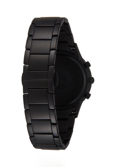 Correa de reloj de eslabones de metal negro que rodea parcialmente una caja de reloj negra con botones laterales, vista desde atrás.