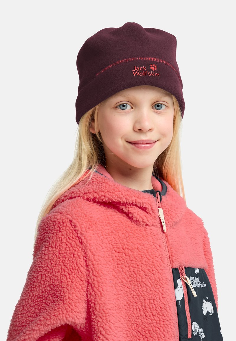 Beanie in pile borgogna con cuciture rosse. Bambino indossa una giacca in pile corallo con una tasca nera caratterizzata da un motivo animale bianco.