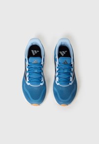 Ténis desportivos azuis com parte superior em malha, detalhes pretos e atacadores azul-claro. Apresenta superfícies texturizadas e sola de borracha.