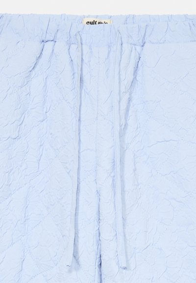 Svetlomodrá prešívaná látka s diamantovým prešívaním, elastickým pásom a dvoma dlhými šnúrkami umiestnenými pod čiastočnou látkovou etikietou.