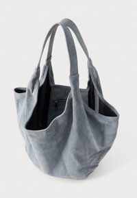 Geantă tote gri din piele întoarsă, cu două mânere, deschisă în partea de sus și buzunar interior cu fermoar. Textură moale și formă flexibilă. Include buzunare laterale.