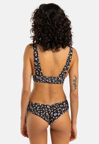 Svart blommig bikini-set med en bred axelbandsbra med rundad rygg och matchande låg midja badbyxor, båda med små vita och rosa blommor.