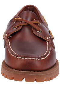 Braune Lederschuhe mit abgerundeter Spitze, braunen Schnürsenkeln und Metallösen. Sie haben eine Kontrastnaht und eine robuste Gummisohle mit Profil.