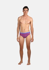 Slips de bain violets avec des rayures horizontales rouges et bleues, dotés d'une taille bleu et d'un petit logo blanc à l'avant.