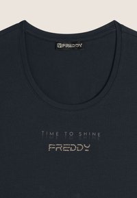 T-shirt nera a maniche corte con scollo a barca, caratterizzata dalla scritta "TIME TO SHINE" e "FREDDY" in un design lucido e tempestato di borchie sul davanti.