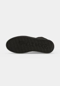 Semelle de chaussure noire avec un motif de bande de roulement rainuré et le nom de la marque "Marco Polo" embossé sur le dessous.