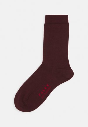 Burgundy sock with a smooth texture, ribbed cuff, and reinforced toe. Features red FALKE branding on the side.