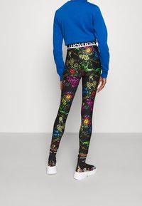 Tights i svart bas med livliga, flerfärgade mönster av utsmyckade former och mönster. Hög midja med logotypdetalj.