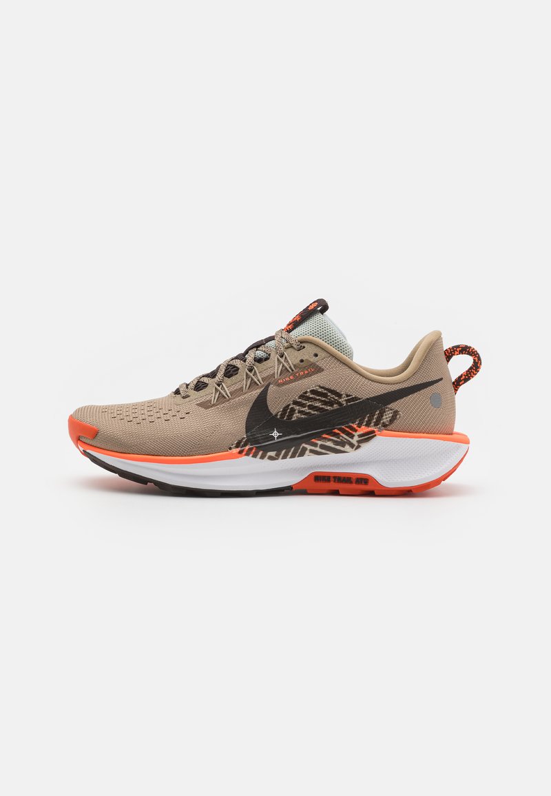 Beige løbesko med et mesh-øvre, sort swoosh, orange accenter, tekstureret sål og mønstret detaljer på siden.