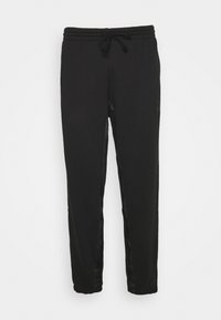 Sorte sweatpants med elastisk talje og snor, med sidelængder og en tapered pasform. Fremstillet af blødt stof.
