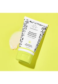 White tube with black patterns and green cap, labeled "Wonderwild Miracle Butter" with marula and meadowfoam oils, on yellow background.