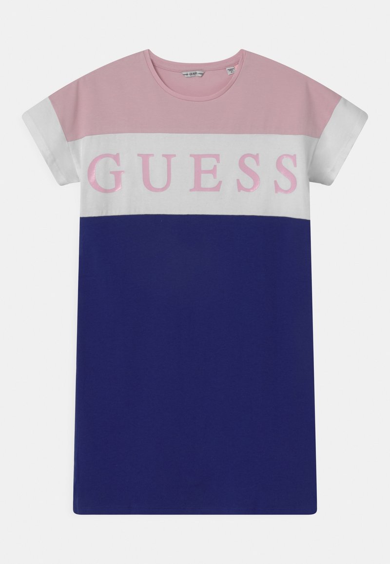 Robe t-shirt avec des blocs de couleurs rose, blanc et marine, avec le texte "GUESS" sur la poitrine en lettres roses.