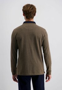 Bruine langarm polo met een visgraatpatroon, voorzien van een marineblauwe kraag. Textuurstof, rechte snit en zijsplitten aan de onderkant.