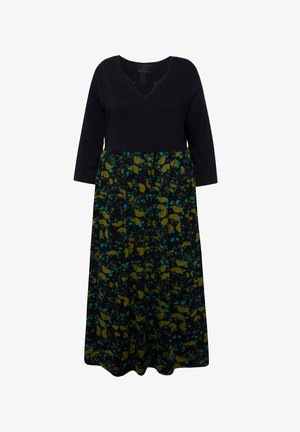 Donkerblauwe jurk met een V-hals en driekwart mouwen. De rok heeft een veelkleurig bladenpatroon op een donkere achtergrond.