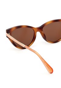 Gafas de sol carey con lentes marrones, diseño de ojo de gato, acentos metálicos y patillas translúcidas naranjas.