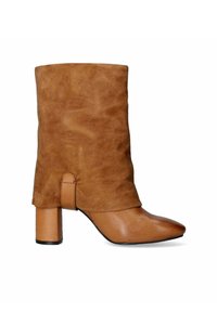 Stivaletto in suede marrone con parte superiore morbida, punta appuntita e tacco spesso. Accento in pelle liscia alla base, caratterizzato da un design piegato.