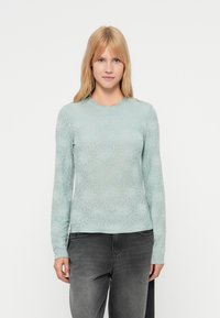 Ανοιχτό πράσινο πουκάμισο με μακριά μανίκια και floral μοτίβο, κατασκευασμένο από απαλό ύφασμα. Διαθέτει στρογγυλή λαιμόκοψη και εφαρμοστή γραμμή.