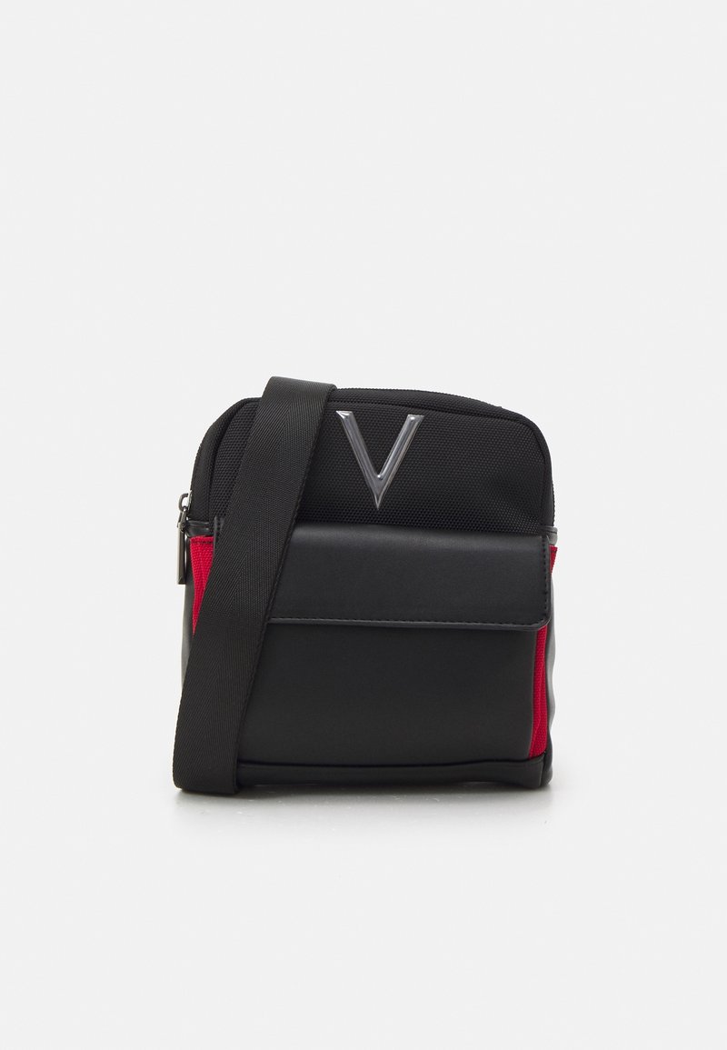 Borsa a tracolla nera con dettagli rossi, realizzata in tessuto testurizzato e pelle liscia. Presenta un logo argentato e una tracolla regolabile.